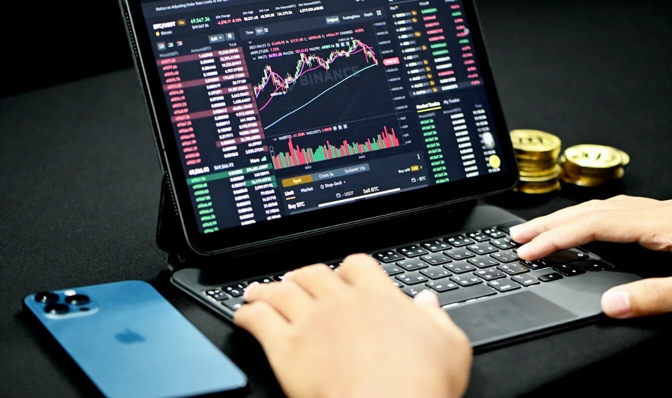 small laptop that is dark showing a trading chart