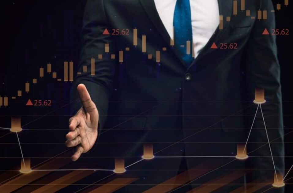 man holding had out in front of trading sheet