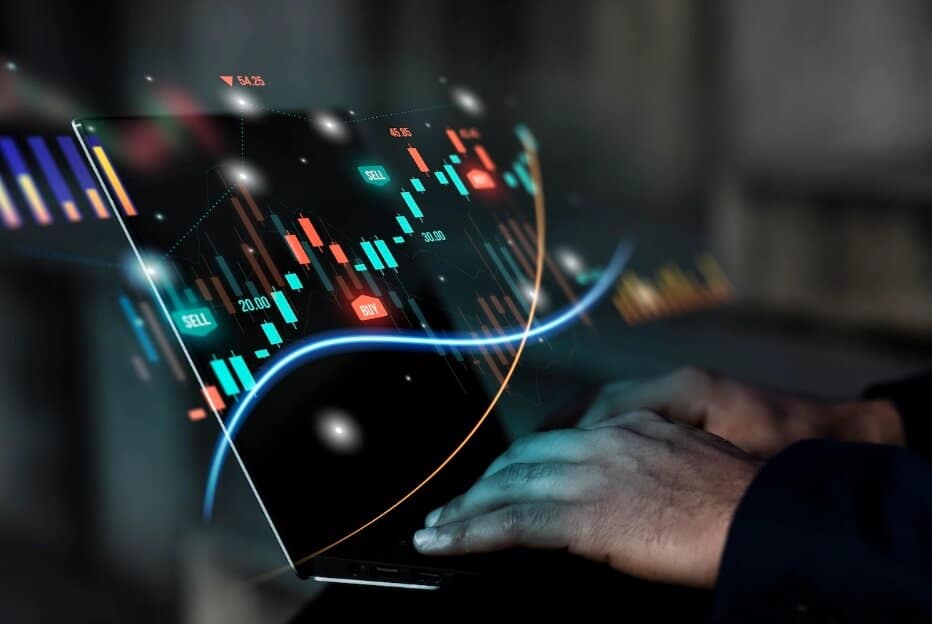 hand typing on laptop showing trading chart