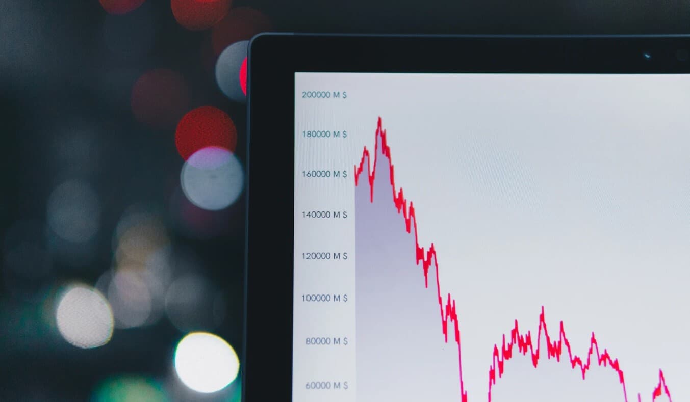 Image of corner of laptop showing a white and red trading chart
