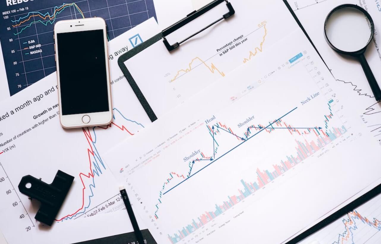 overview of desk with phone and trading charts