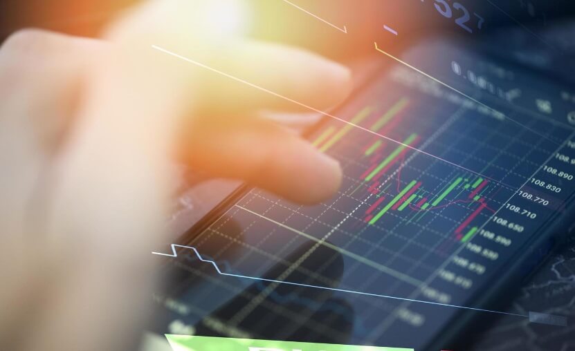 finger touching phone with glare showing trading chart