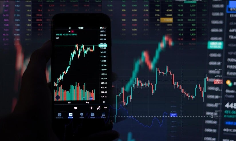 close up of phone and laptop showing trading chart