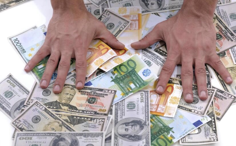hands rubbing a pile of money