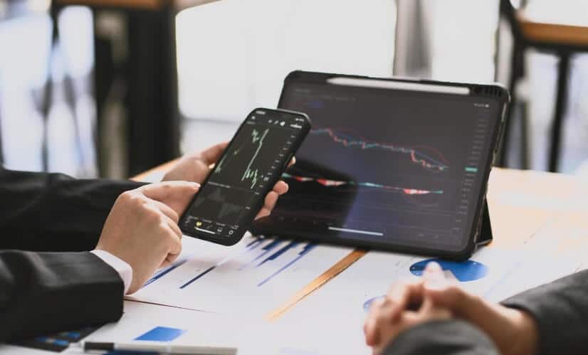 phone and tablet with hand showing forex chart