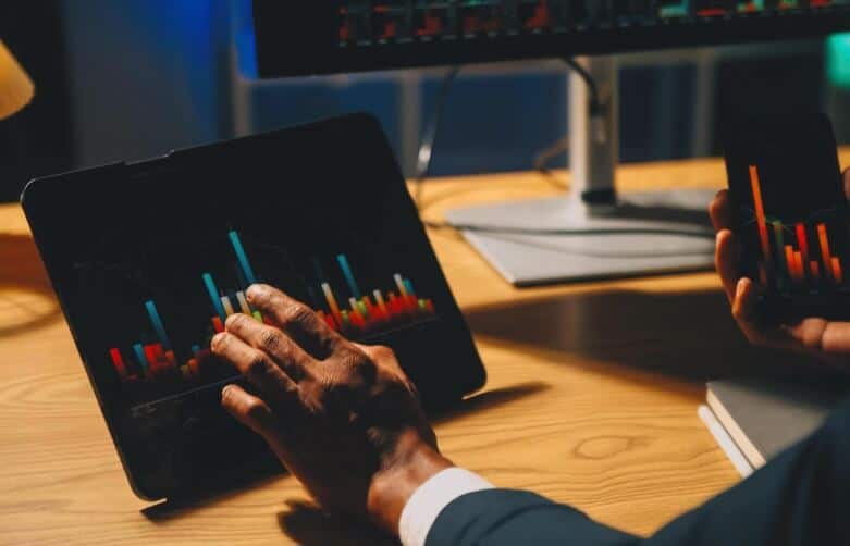 man trading on tablet showing detailed forex chart