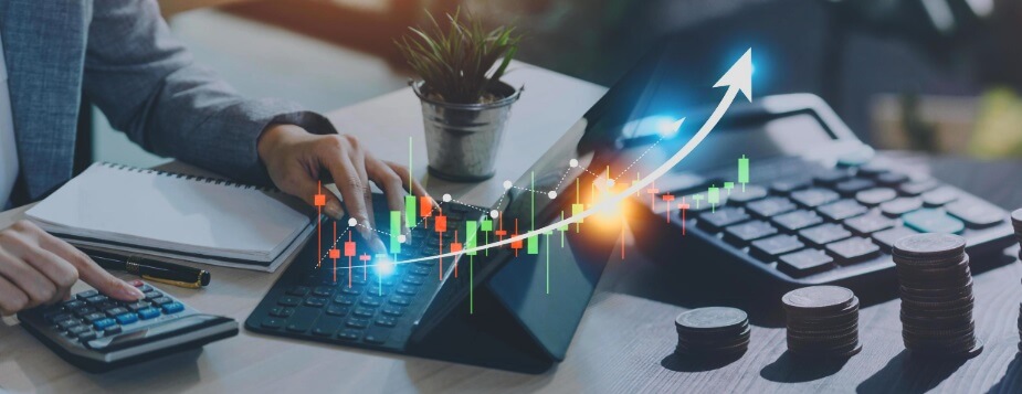 laptop and calculator behind forex trading chart