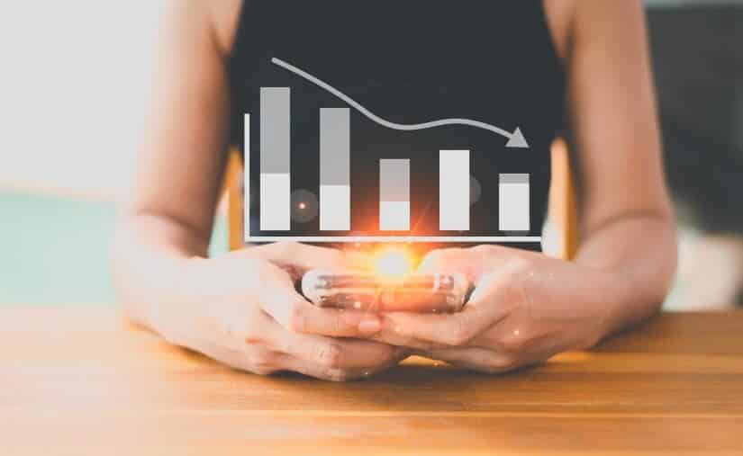 woman holding phone with 2 hands showing forex chart going down