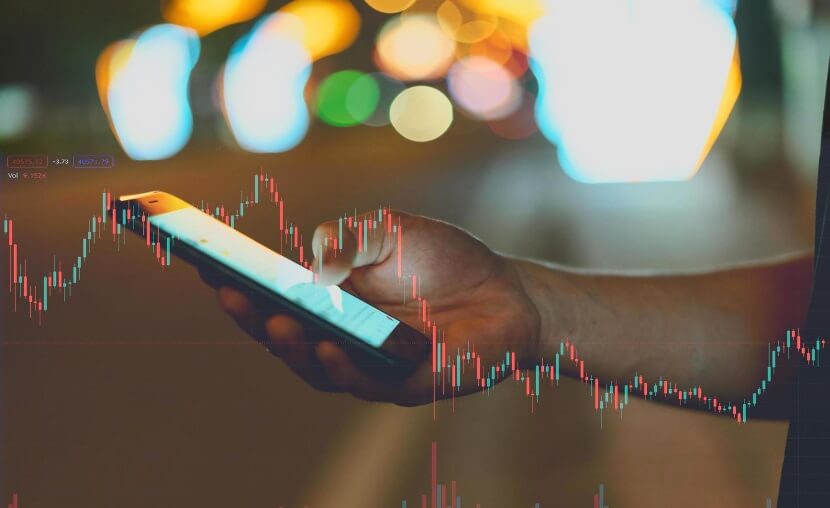 hand holding phone with forex chart overlay